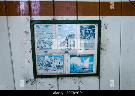 Bahnfahrplan und Reiseplakate am stillgelegten Bahnhof Honing in der Nähe des kleinen Dorfes Honing, Norfolk, sind jetzt Teil des Weaver's Way. Stockfoto