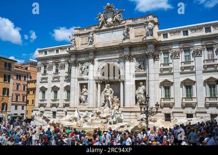 Der Trevi-Brunnen mit dem imposanten Palazzo Poli auf der Piazza di Trevi in Rom, Region Latium, Italien, ist von Touristen umgeben Stockfoto