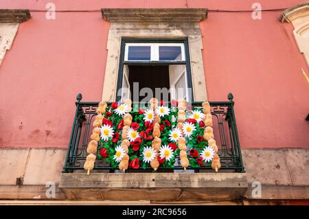 Tomar, Portugal - 8. Juli 2023: Balkon mit Papierblumen und Brot auf einer Straße in der Stadt Tomar in Portugal. Stockfoto