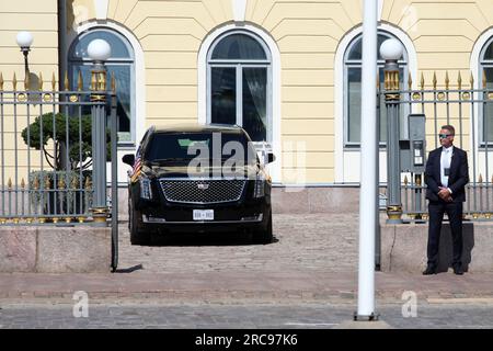 Helsinki, Finnland. 13. Juli 2023. Die Limousine des US-Präsidenten namens „The Beast“ parkt vor dem finnischen Präsidentenpalast mit einem Wachmann am Eingang. USA Präsident Joe Biden traf sich mit dem finnischen Präsidenten Niinistö zu einem bilateralen Treffen, nach dem im Palast ein Gipfeltreffen mit den Regierungschefs der anderen nordischen Länder geplant war. Kredit: Steffen Trumpf/dpa/Alamy Live News Stockfoto