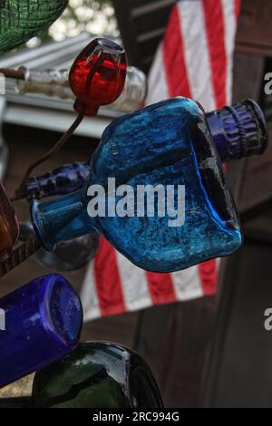 Klassische recycelte Flaschen auf Metallgestell mit amerikanischer Flagge Stockfoto