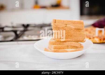In der Küche auf einem weißen Teller gestapelte Brotpflaster Stockfoto