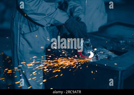 Industriearbeiter, der einen Winkelschleifer verwendet und eine Metallplatte schneidet. Grafik zur Schwermetallindustrie in der Fabrik für Werbung. Stockfoto