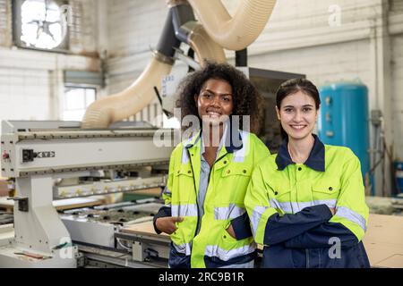 Weibliche Mitarbeiterin Teammitarbeiter in einer Industriefabrik glücklich lächelnd Porträt zusammenstehend multiethnisch Stockfoto