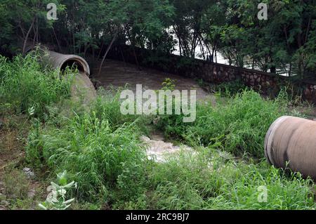 East Delhi, Delhi, Indien. 13. Juli 2023. Wasser fließt in vollem Durchfluss aus der Hauptwasserleitung Wasser fließt aus und fließt in Richtung der Volkskolonie und Häuser, Eine Residenz des Ufers des yamuna nun von der Flut betroffene Familien bleiben auf der Straße des National Highway Safer Place, nachdem der Fluss Yamuna übergelaufen ist, in Neu Delhi am 13. Juli 2023. Am 13. juli 2023 in Ost-Delhi am Donnerstag .Foto von Ravi Batra (Kreditbild: © Ravi Batra/ZUMA Press Wire) NUR REDAKTIONELLER GEBRAUCH! Nicht für den kommerziellen GEBRAUCH! Stockfoto