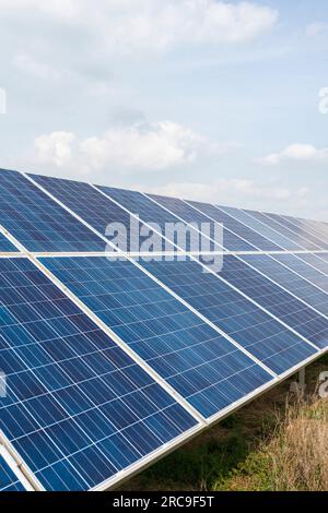 Eine Bank mit großen Solarpaneelen als Teil einer Solarfarm auf Ackerland in Gloucestershire, England Stockfoto