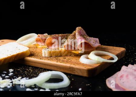 Würstchen Mortadella und Zwiebeln auf dem Schneidebrett Stockfoto