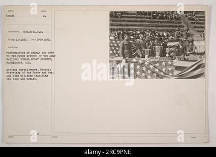 Alter am 5. Mai 1920 in Washington, D.C. Das Foto zeigt die Präsentation von Medaillen und Pokalen an die Preisträger des Army National School Essay Contest. Auf dem Bild sehen Sie General March, General Harris, Kriegsminister Baker, und Mrs. Und Miss Milliken, wie sie die Pokale und Medaillen untersuchen. Der Fotograf ist S.C. Hitz. Stockfoto