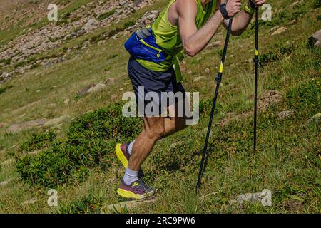 Mann mit Wanderstöcken steil bergauf beim Mountain Marathon Race Stockfoto