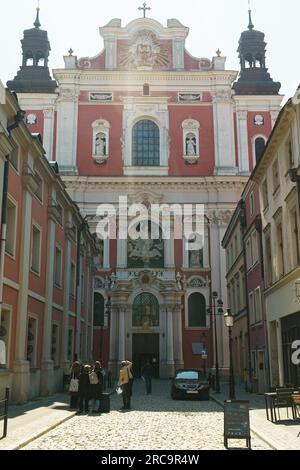 Posen, Polen - 21. April 2023: Touristen in der Nähe der römisch-katholischen Basilika in Posen, auch bekannt als Pfarrkirche St. Stanislaus. Stockfoto