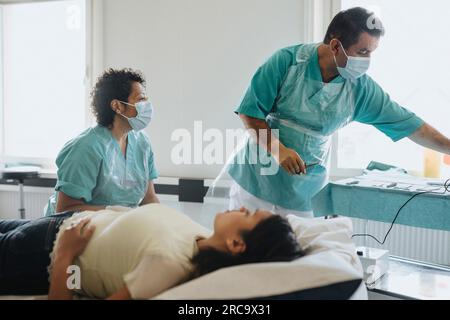 Chirurgen in Masken untersuchen Patientinnen im Krankenhaus Stockfoto
