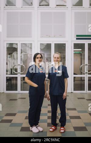 Portrait einer lächelnden Mitarbeiterin im Gesundheitswesen, die vor dem Krankenhaus steht Stockfoto