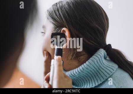 Arzt untersucht das Ohr des Patienten mit dem Otoskop im Krankenhaus Stockfoto