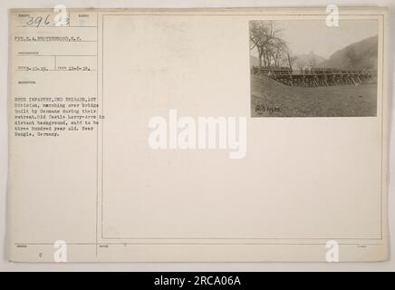 Soldat E.A. Die Bruderschaft von South Carolina wurde während des Ersten Weltkriegs fotografiert. Das Bild zeigt, wie er mit der 28. Infanterie, der 2. Brigade, der 1. Division über eine Brücke marschiert, die von den zurückziehenden Deutschen gebaut wurde. Die Old Castle LKW-ARRS ist im fernen Hintergrund zu sehen, der angeblich dreihundert Jahre alt ist. Aufgenommen in der Nähe von Bengle, Deutschland. Lichtbildausweis: 111-SC-39623. Stockfoto