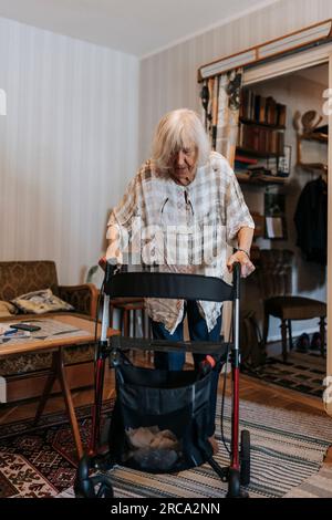 Seniorin zu Hause mit Gehhilfe Stockfoto