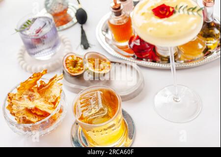 Fünf farbenfrohe Sommercocktails in Gläsern auf einem weißen Tisch. Auswahl an frischen Sommergetränken. Orange- und rote Sangria-Cocktails, Orangen-Punsch-Cocktails, Stockfoto