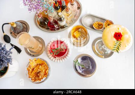 Fünf farbenfrohe Sommercocktails in Gläsern auf einem weißen Tisch. Auswahl an frischen Sommergetränken. Orange- und rote Sangria-Cocktails, Orangen-Punsch-Cocktails, Stockfoto