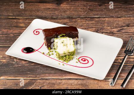 Köstlicher Brownie mit Vanilleeis auf einem weißen Porzellanteller Stockfoto