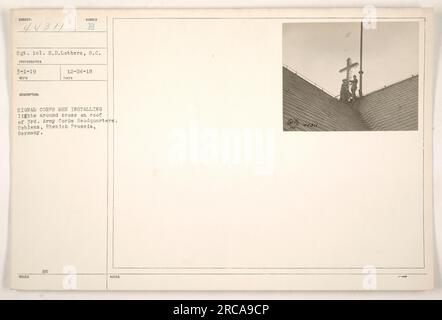 Sgt. H.D. Lothers, S.C., in Begleitung anderer Signalkorps-Männer, ist auf dem Foto zu sehen, wie sie Lichter um das Kreuz herum installieren, das sich auf dem Dach des 3. Armeekorps-Hauptquartiers in Coblens, Rhenish Preussia, Deutschland befindet. Das Foto wurde am 1. März 1919 aufgenommen und hat die Nummer 44311. Stockfoto