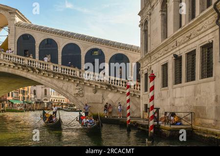 Touristen am Gondelpier zwischen der Rialtobrücke und dem Palazzo dei Camerlenghi auf dem Canale Grande im Sommer, Venedig, Veneto, Italien Stockfoto