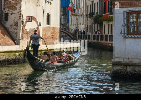 Touristen genießen eine Gondelfahrt auf dem Rio de San Trovaso Kanal mit dem Palazzo Rocca Contarini Corfù (links), Sestiere von Dorsoduro, Venedig, Italien Stockfoto