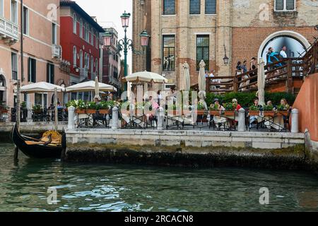 Touristen in einem Restaurant am Wasser neben der Accademia-Brücke am Canale Grande im Sommer, Venedig, Venetien, Italien Stockfoto