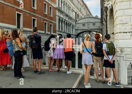 Touristen auf der Strohbrücke bewundern und fotografieren die berühmte Seufzerbrücke auf dem Rio di Palazzo Kanal, Venedig, Veneto, Italien Stockfoto