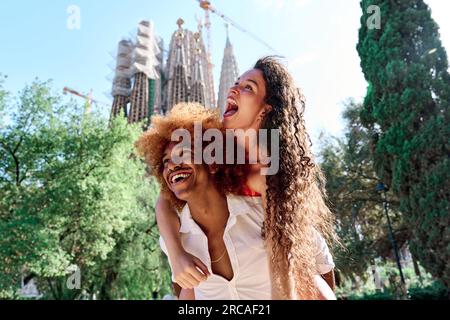 Glückliches Paar von Touristen, die Huckepack machen und Spaß in Barcelona, Spanien haben Stockfoto