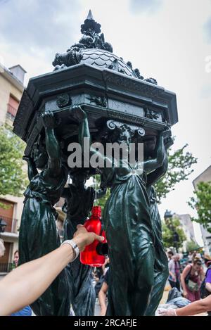 Eine Frau, die ihre Flasche am Wallace-Brunnen füllt. Es sind öffentliche Trinkbrunnen, benannt nach, finanziert und grob entworfen von Sir Richard Wall Stockfoto
