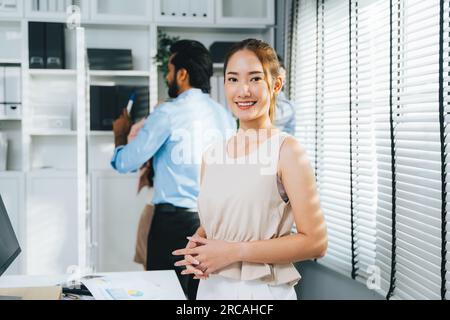 Porträt einer selbstbewussten Geschäftsfrau, die in die Kamera schaut, Geschäftsteam-Meetings und Brainstorming im Unternehmen, Mitarbeiter, die mit dem Laptop arbeiten Stockfoto