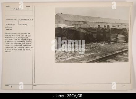 Außenansicht eines medizinischen Versorgungsdepots am Medical Supply Depot Nr. 2 in der Nähe von Gievre, Loire et Cher, Frankreich. Die Abbildung zeigt ein Lager im Hintergrund und die Speicherung von Federbetten im Vordergrund. Drei Offiziere des Sanitär-Corps, Major S. Smekey, Lieut. BLUTDRUCK Luxcomb und Lieut. F.J. Sheffler ist von links nach rechts zu sehen. Das Foto wurde von S.C. Sot aufgenommen. J. W. Crunelle am 1. Februar 1919. Stockfoto