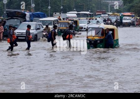 Neu-Delhi, Indien. 13. Juli 2023. Ein Auto-Rikscha-Fahrer waten durch das überschwemmte Gebiet in der Nähe der Ringstraße, während der Wasserstand in Neu-Delhi zunahm. Das Hochwasser erreichte die Ringstraße und das Wohngebiet nach starken Regenfällen und Wasseraustritt aus der Hathnikund-Barrage. Der Wasserstand des Yamuna-Flusses erreichte 208,63 Meter und brach 1978 laut offizieller Angaben vor 45 Jahren. Kredit: SOPA Images Limited/Alamy Live News Stockfoto