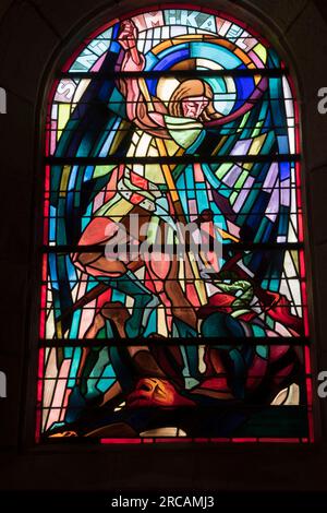 Erzengel Michael mit Schwert, Buntglasfenster mit dem Erzengel St. Michael. Der heilige Michael ist kein heiliger, sondern ein Engel und der Anführer aller Engel und der Armee Gottes. Saint Michel en Greve, Cotes-d'Armor, Bretagne, Frankreich. 10. Juli 2023 2020s HOMER SYKES Stockfoto