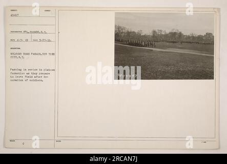 Soldaten bereiten sich darauf vor, das Feld nach einer Dekorationszeremonie während einer Willkommensparade in New York City zu verlassen. Das Foto wurde am 27. März 1919 aufgenommen und zeigt die Soldaten, die nach der Parade in Platoon-Formation marschieren. Dieses Bild ist aus einer Reihe von Fotografien amerikanischer Militäraktionen während des Ersten Weltkriegs. Stockfoto