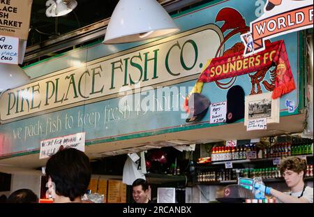 Berühmt für Fisch, der die Käufe von Kunden wirft, bevor er den Pike Place Fish Market Seattle Washington State USA einpackt Stockfoto