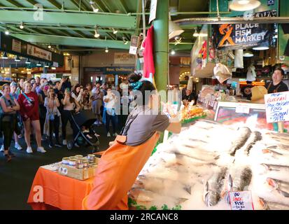 Berühmt für Fisch, der die Käufe von Kunden wirft, bevor er den Pike Place Fish Market Seattle Washington State USA einpackt Stockfoto