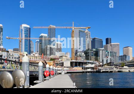 Skyline der Stadt mit einem Bauprojekt und Turmkränen entlang der Uferpromenade von einem schwimmenden Pier 62 Seattle Washington State USA Stockfoto