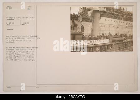 Die USS Mandschurie (ID-1633) erreicht die Docks in Hoboken, NJ, mit 4447 Mann an Bord, darunter Mitglieder des 71. Regiments C.A.C. und Verletzte. Das erste Willkommenshaus für die Truppen wird empfangen, als das New Yorker Polizeiboot „Patrol“ mit Mitgliedern des Willkommenskomitees des Bürgermeisters dazukommt. Zeitungen, Obst und Tabak werden an Bord geworfen, und die Polizeikapelle spielt. Das Bild erfasst den Moment der Begrüßung. Stockfoto