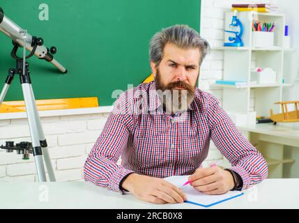 Zurück in die Schule. Lernen, Bildung. Der Lehrer bereitet den Unterricht im Klassenzimmer vor. Prüfung im College. College-Student macht Notizen in Notizbuch. Schüler in Stockfoto