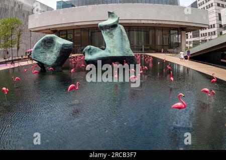 Am Sonntag, den 2. Juli 2023, teilen sich die rosa Flamingos mit Henry Moores „Liegende Figur“ im Lincoln Center in New York das reflektierende Becken. Im Rahmen des „Summer for the City“-Festivals werden Hunderte von kostenlosen Veranstaltungen angeboten. (© Richard B. Levine) Stockfoto