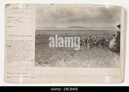 Soldaten in olivbrauner Farbe überqueren einen Vorratszug, während sie den St. Mihiel war im Ersten Weltkrieg besonders wichtig. Das Foto wurde am 5. Oktober 1918 aufgenommen und zeigt amerikanische Truppen, die auf den Rückzug der Deutschen drängen. Im Hintergrund ist Montsec, ein befestigter Hügel, zu sehen, der am ersten Tag des Angriffs in amerikanische Hände fiel. Foto von A.E.F.-Zensor. Stockfoto