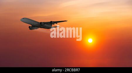 Gewerbliche Passagierflugzeuge, die über den Wolken im Sonnenlicht fliegen. Stockfoto