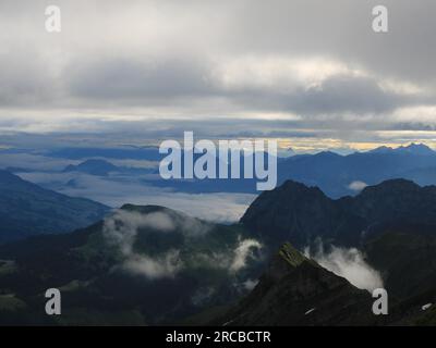 Sonnenaufgangsszene vom Mount Brienzer Rothorn aus gesehen. Blick auf Stanserhorn und Luzern. Nebel hebt sich langsam nach einer regnerischen Nacht Stockfoto