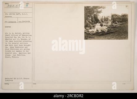 Leutnant G. W. Wright, Leutnant H. L. Wheeler und Leutnant Brooke vom Evakuierungskrankenhaus Nr. 14 leisten den Verwundeten medizinische Hilfe, während Miss Rochester und Miss Stevenson Getränke und Zigaretten anbieten. Diese Unterstützung des amerikanischen Roten Kreuzes fand während des Ersten Weltkriegs in Les Islettes, Mause, Frankreich statt." Stockfoto