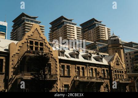 Baku, Aserbaidschan - 26. Juni 2023: Dieses dynamische Stadtbild spiegelt den Kontrast zwischen Bakus Old Street Hotel aus der Sowjetzeit und dem modernen Port Baku Nor wider Stockfoto