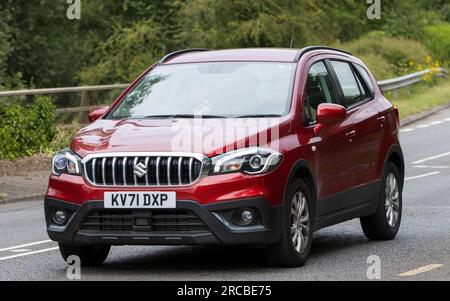 Milton Keynes, Großbritannien - Juli 13. 2023: 2021 roter Hybrid-Elektro-SUZUKI SX4 S-CROSS SZ4 B-JET MHEV-Wagen, der auf einer englischen Straße fährt Stockfoto