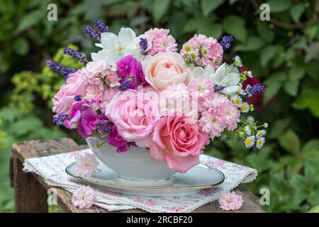 Romantischer Strauß von rosa Rosen, süßen Erbsen, Lavendel und Jasminblumen in altem Saucen-Boot Stockfoto