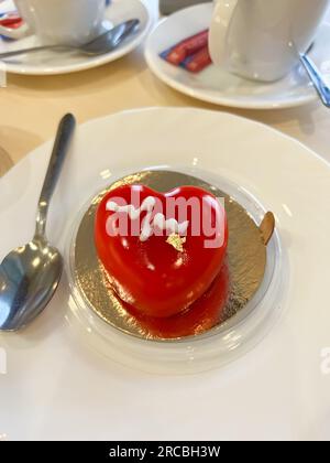 Kuchenherz mit essbarem Gold auf dem Tisch Stockfoto