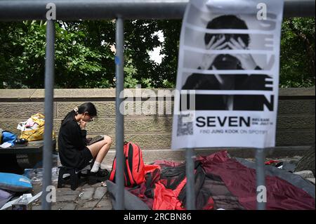 New York, USA. 13. Juli 2023. Ein junges Mädchen sitzt vor dem Central Park mit einem iPad und wartet in der Schlange, um dem koreanischen K-POP BTS-Bandmitglied Jung Kook beim Konzert in New York, NY, am 13. Juli 2023 beizuwohnen. Fans des BTS-Mitglieds zelten seit mehreren Tagen auf der 5. Avenue, in der Hoffnung, einen guten Platz zu bekommen, um Jung Kook bei der Good Morning America's Concert Series zu sehen. (Foto: Anthony Behar/Sipa USA) Guthaben: SIPA USA/Alamy Live News Stockfoto