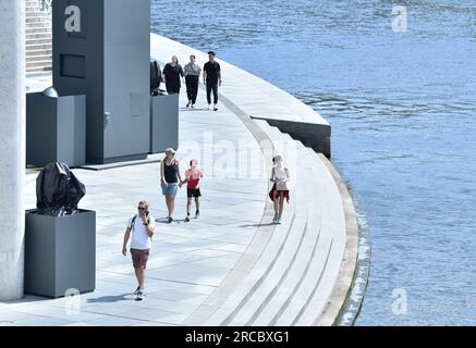 Berlin, Deutschland. 13. Juli 2023. Menschen gehen am 13. Juli 2023 an einem Fluss in Berlin vorbei. Kredit: Ren Pengfei/Xinhua/Alamy Live News Stockfoto